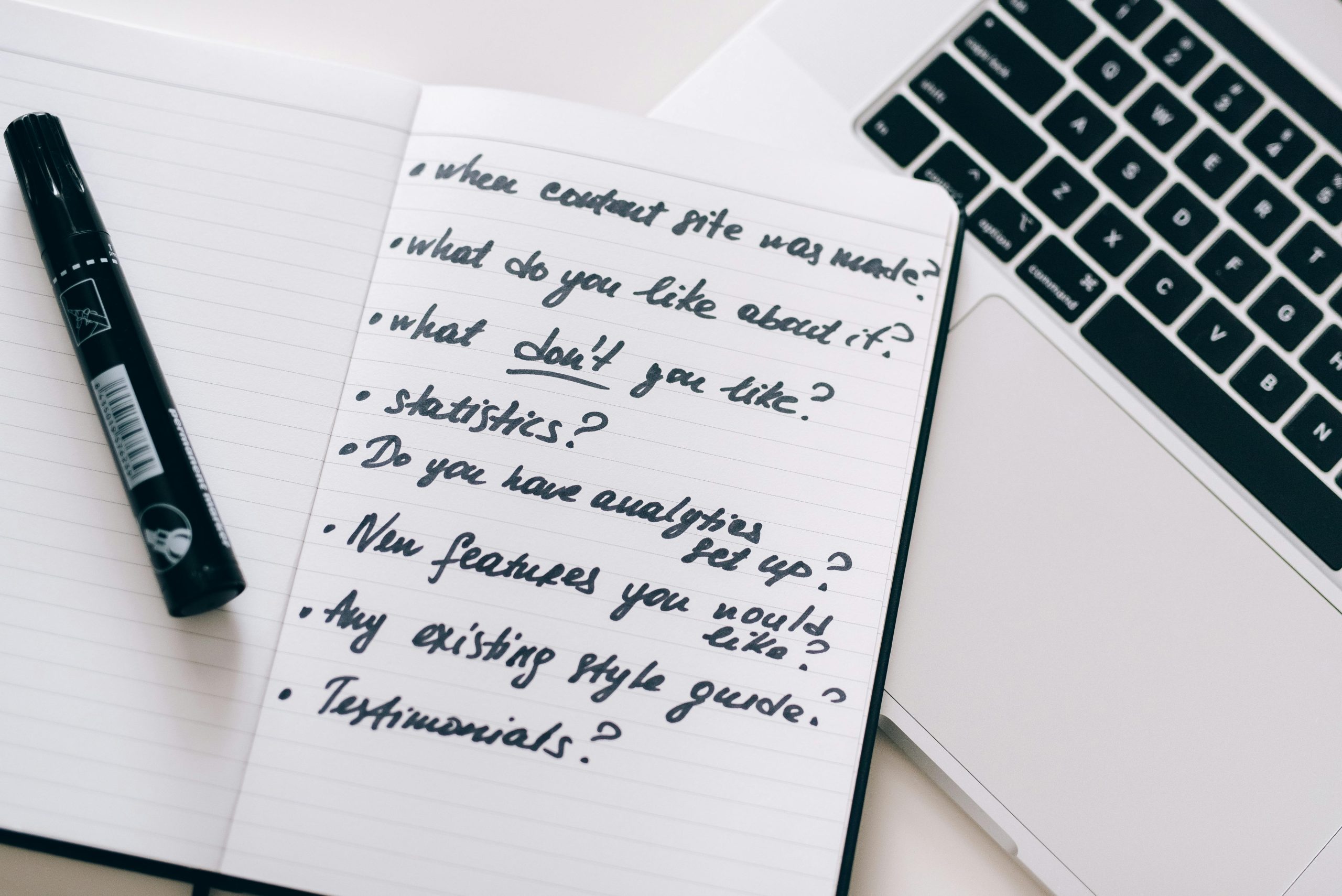 Close-up of a notebook with handwritten notes next to a laptop, ideal for business or educational content.